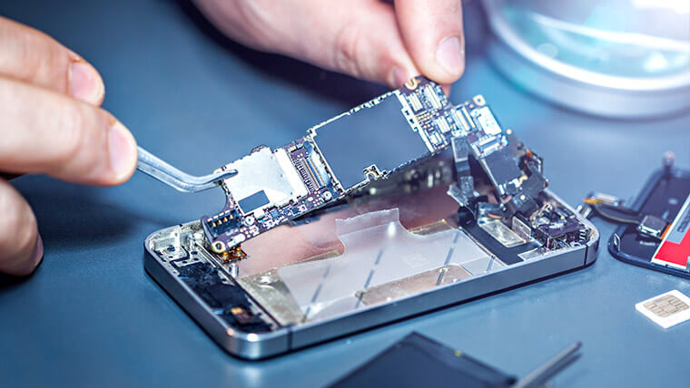 Techniker_repariert_Handy_ Technician repairing a smartphone